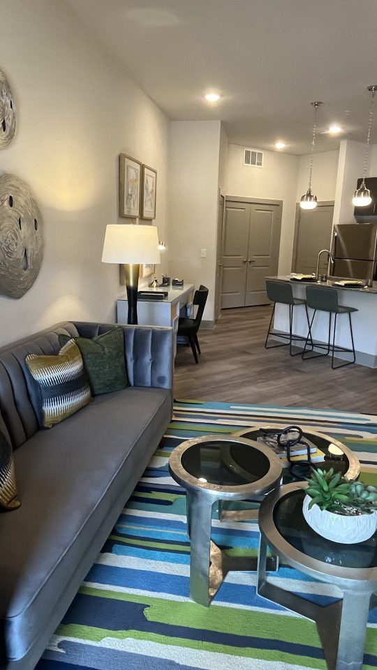 a living room with a couch, coffee table and chairs at The Lofts at Allen Ridge