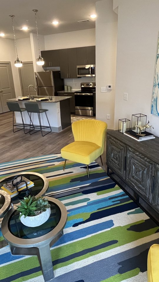 a living room with a blue and yellow rug at The Lofts at Allen Ridge