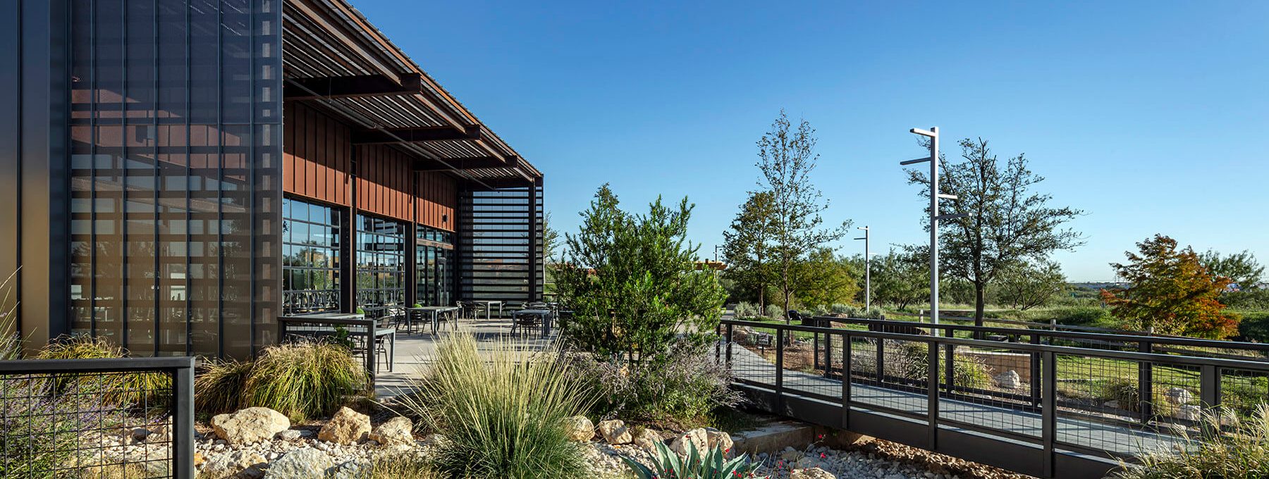 the exterior of a building with a walkway and landscaping at The Lofts at Allen Ridge