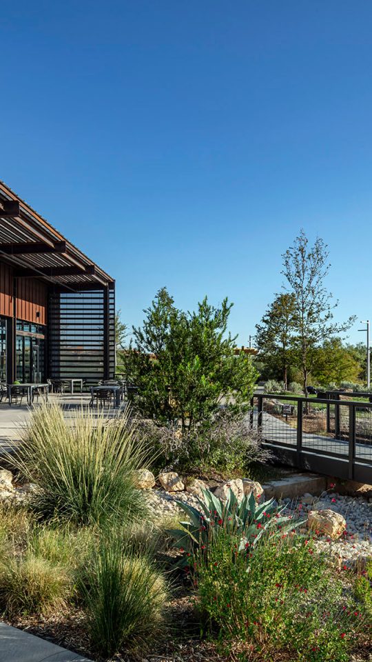 the exterior of a building with a walkway and landscaping at The Lofts at Allen Ridge