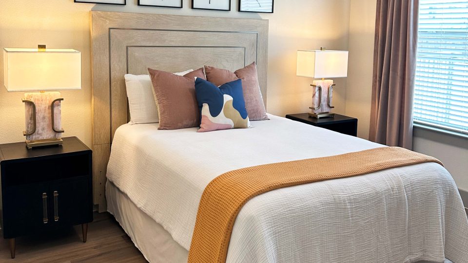 a bedroom with a white bed and two pictures on the wall at The Lofts at Allen Ridge