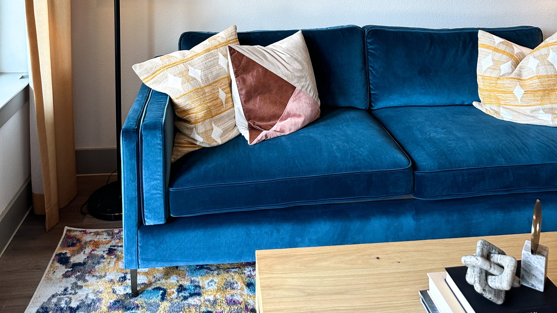 a blue velvet couch in a living room at The Lofts at Allen Ridge