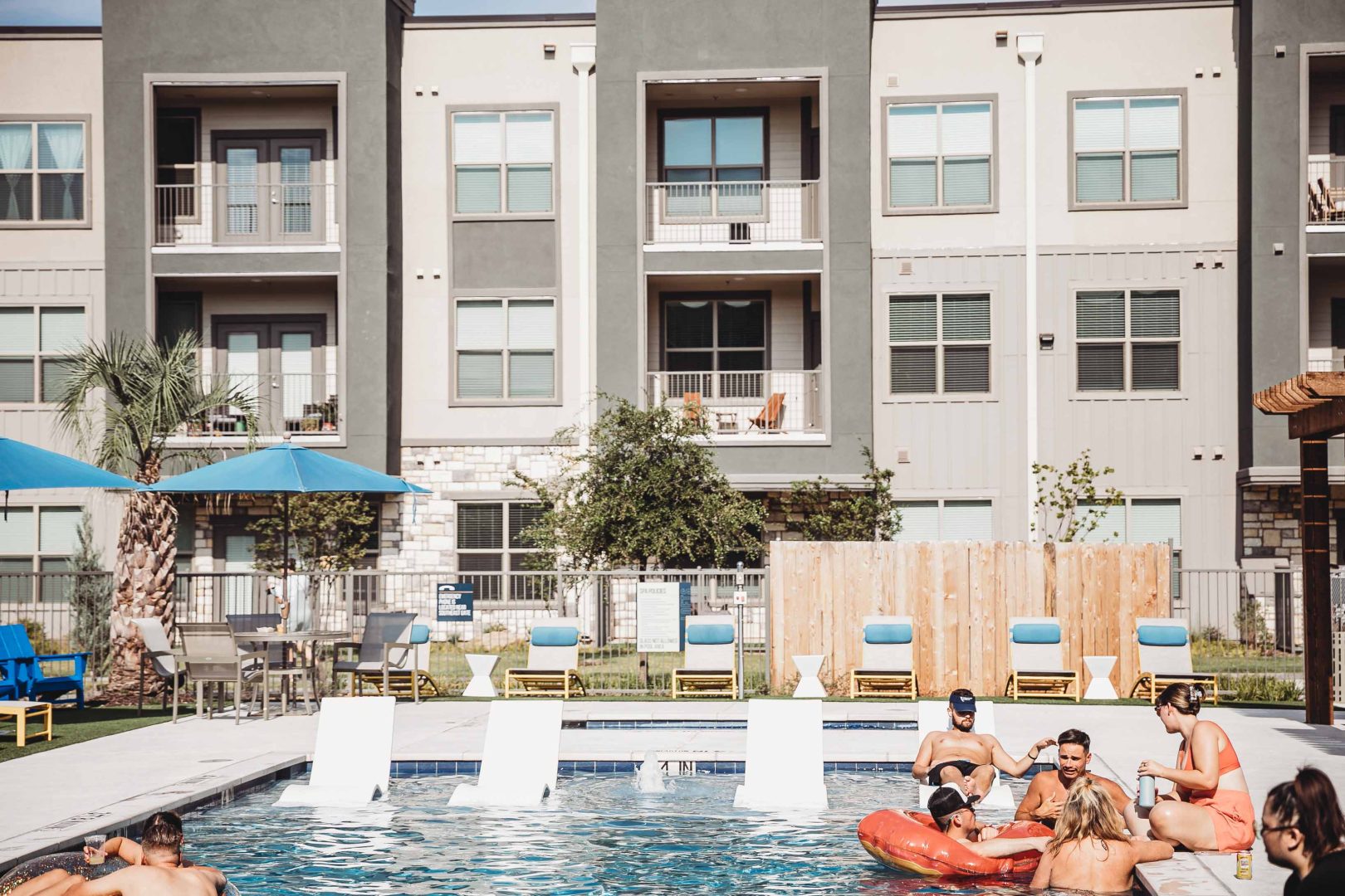 people are relaxing in the pool at an apartment complex at The Lofts at Allen Ridge